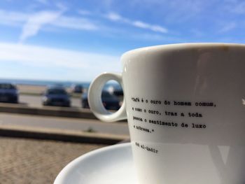 Close-up of coffee cup against sky