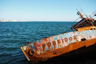 Abandoned ship on sea against clear sky