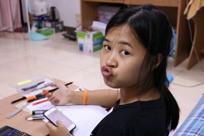 Close-up portrait of girl puckering while studying at home