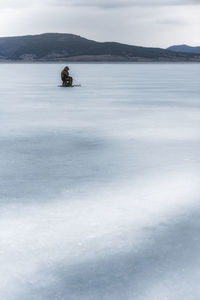 Scenic view of frozen lake against mountain during winter