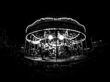 Close-up of illuminated carousel against sky at night