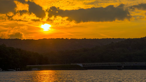 Scenic view of river against orange sky