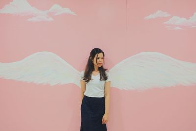 Portrait of woman standing against wall