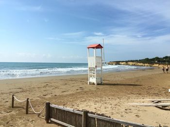 Lifeguard hut on beach against sky