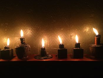 Close-up of illuminated tea light candles against black background