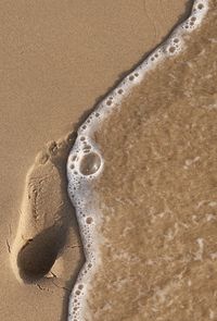 High angle view of footprints on sand at beach