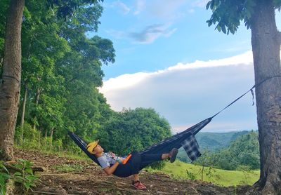 Man amidst trees against sky