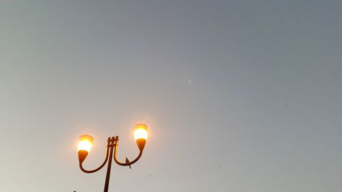 Low angle view of illuminated street light against sky