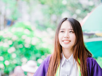 Close-up of smiling woman looking away while standing outdoors