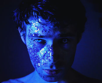 Portrait of young man against blue background