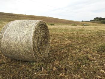 Hay bales on field against sky