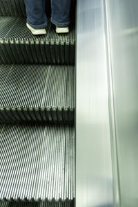 Low section of person on escalator