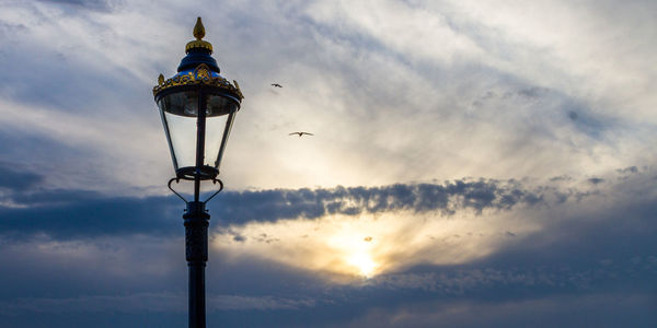 Low angle view of gas light against sky during sunset