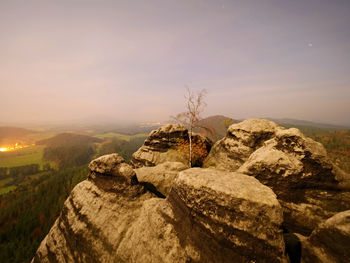 Rock formations on landscape against sky during sunset