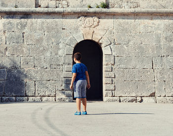 Full length of man standing against wall