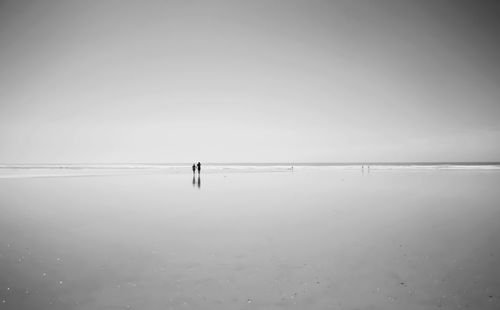 Silhouette of people walking on beach