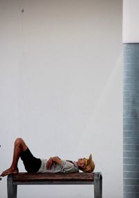 Close-up of woman relaxing on wall