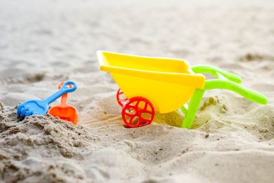 Close-up of yellow toy on beach