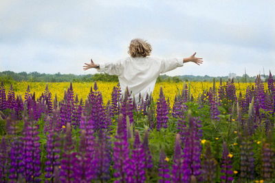 Rear view of woman on field against sky