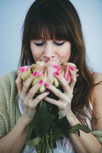 Close-up of woman smelling pink roses