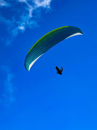 Low angle view of kite flying against blue sky