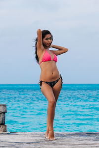 Young woman in bikini standing at beach