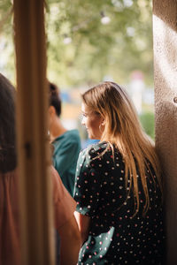 Rear view of woman standing against wall