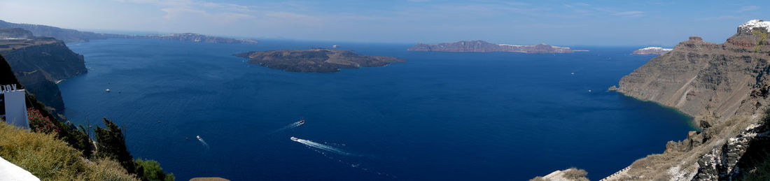 Panoramic view of sea and mountains against blue sky