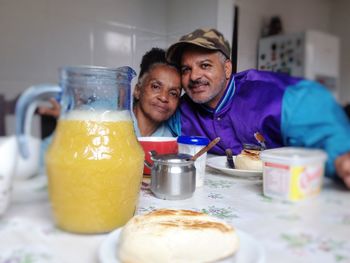 Portrait of man and woman by breakfast on table