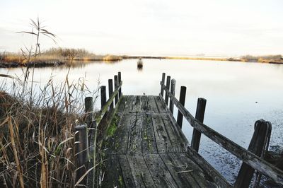 Wooden pier over lake against sky