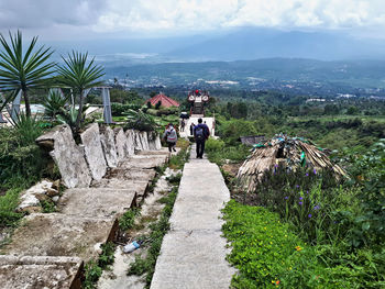 Rear view of people on mountain against sky