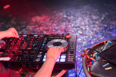 Close-up of woman playing music on audio equipment in nightclub