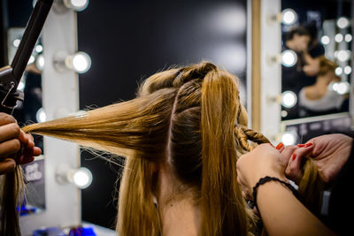 Cropped image of hairdressers with woman hair salon