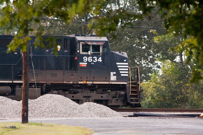 Train by railroad tracks against trees