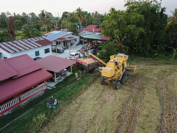 High angle view of house amidst trees on field