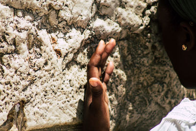 High angle view of man hand on rock