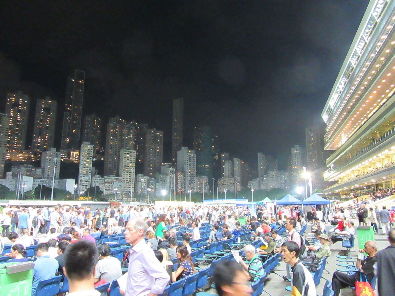 large group of people, crowd, built structure, architecture, building exterior, night, illuminated, real people, crowded, men, travel destinations, lifestyles, women, city, leisure activity, skyscraper, outdoors, modern, cityscape, sky, people, adult