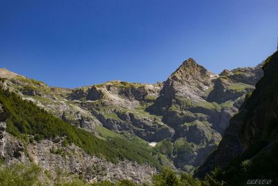 Scenic view of rocky mountains against clear blue sky