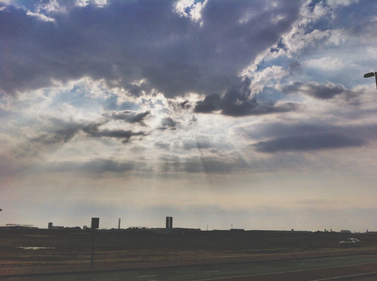 sky, cloud - sky, silhouette, cloudy, sunset, cloud, landscape, built structure, tranquility, field, architecture, nature, building exterior, tranquil scene, beauty in nature, scenics, outdoors, sunlight, dusk, dramatic sky