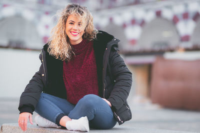 Portrait of smiling woman sitting on snow