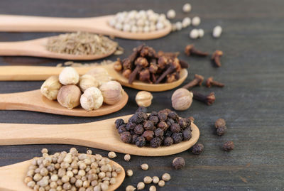 Assortment of spices in spoons lined up on wooden table with selective focus