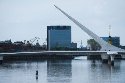 Bridge over river in city against sky