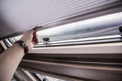 Cropped hand of man opening window in van