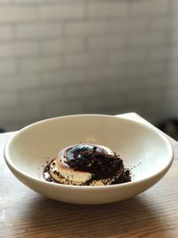 Close-up of ground coffee on ice cream in bowl at table