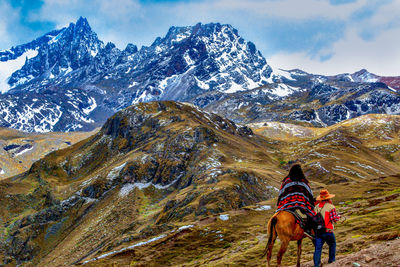 Rear view of horse on mountain against sky