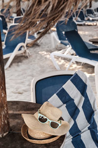 High angle view of hats with sunglasses on table at beach