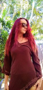 Portrait of young woman against tree
