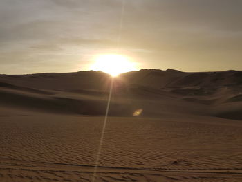 Scenic view of desert against sky during sunset