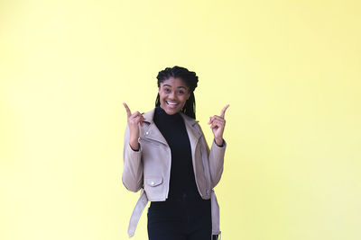 Portrait of smiling young woman against gray background