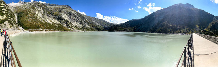 Scenic view of lake by mountains against sky